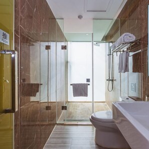 A modern bathroom with a glass shower enclosure, a toilet, and a vanity with a towel rack. - Vyluk J Hotel Guiyang Railway Station (Guiyang)