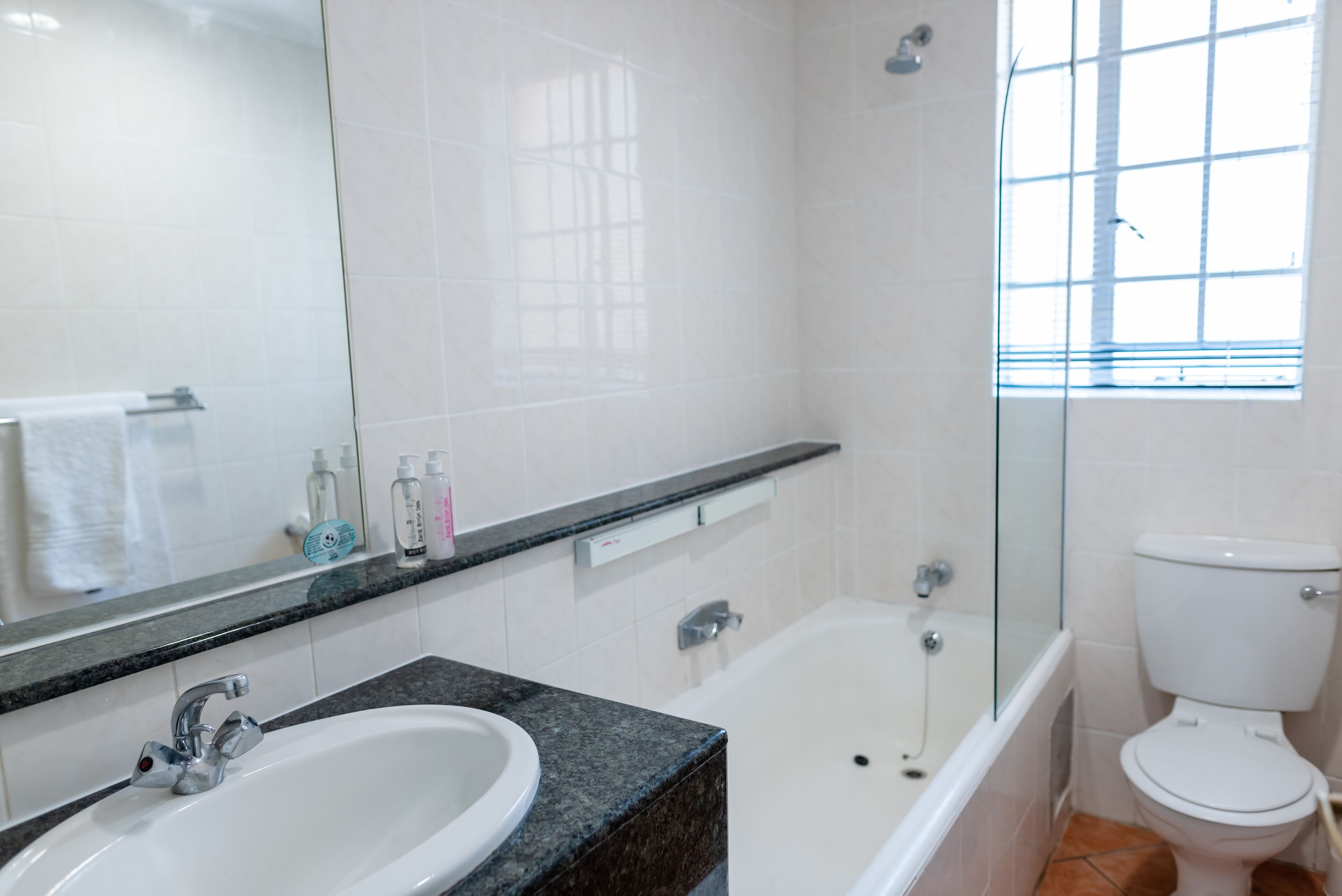 combined shower/bathtub, towels, shampoo, toilet paper