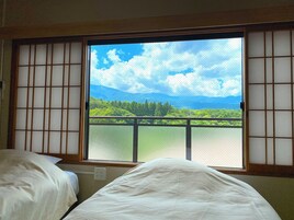 Una habitación con un amplio ventanal que ofrece vistas a un paisaje verde y montañas.