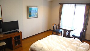 A hotel room with a bed, a television, a small table, and a chair. - Bardenya Soho (Zao)