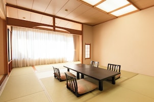 Una habitación japonesa tradicional con suelo de tatami, una mesa baja y sillas de madera.