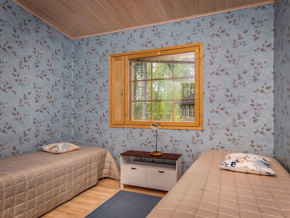 Een kamer met twee bedden, een raam en een bureau.