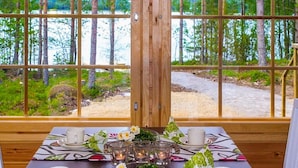 Una mesa de comedor dispuesta con tazas y platillos blancos, un candelabro de vidrio y un centro de mesa floral.