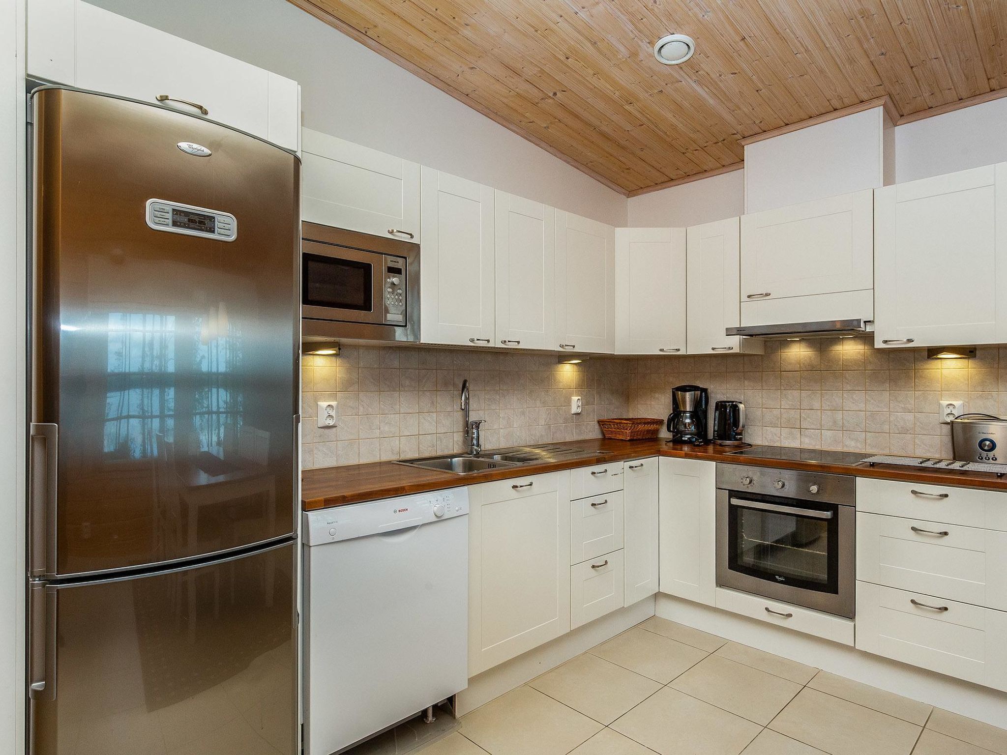 Een koelkast, een magnetron, een vaatwasser, kookgerei, borden en bestek