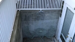 A narrow outdoor staircase with white railings, a concrete wall, and a metal table with chairs. - Extend your rest in the Wellesley Square's best (Wellesley)