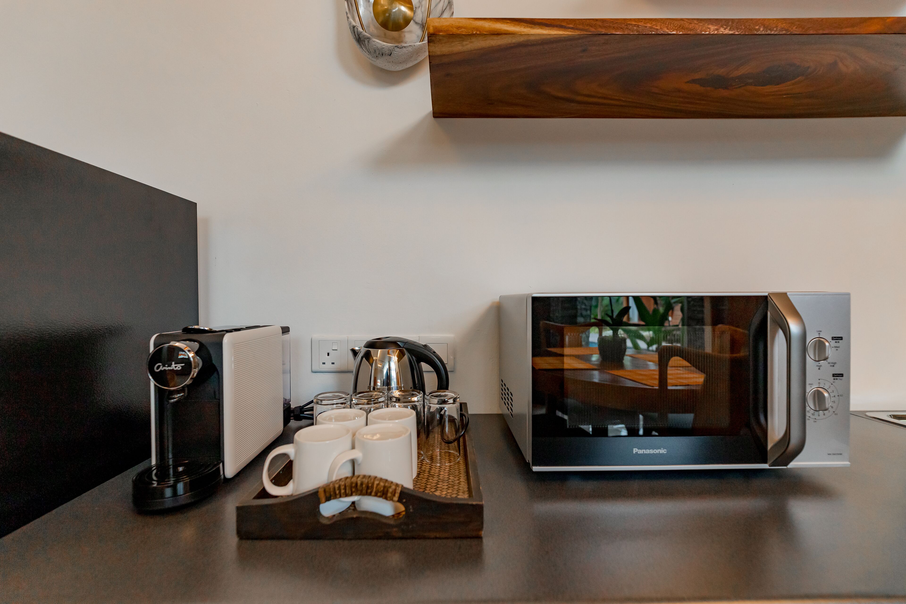 Un plan de travail de cuisine avec une machine à café, un grille-pain et un four à micro-ondes.