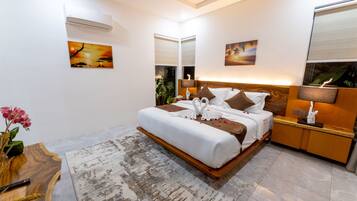 A modern hotel room with a large bed, a wooden bedside table, a nightstand, a desk, and a large window.