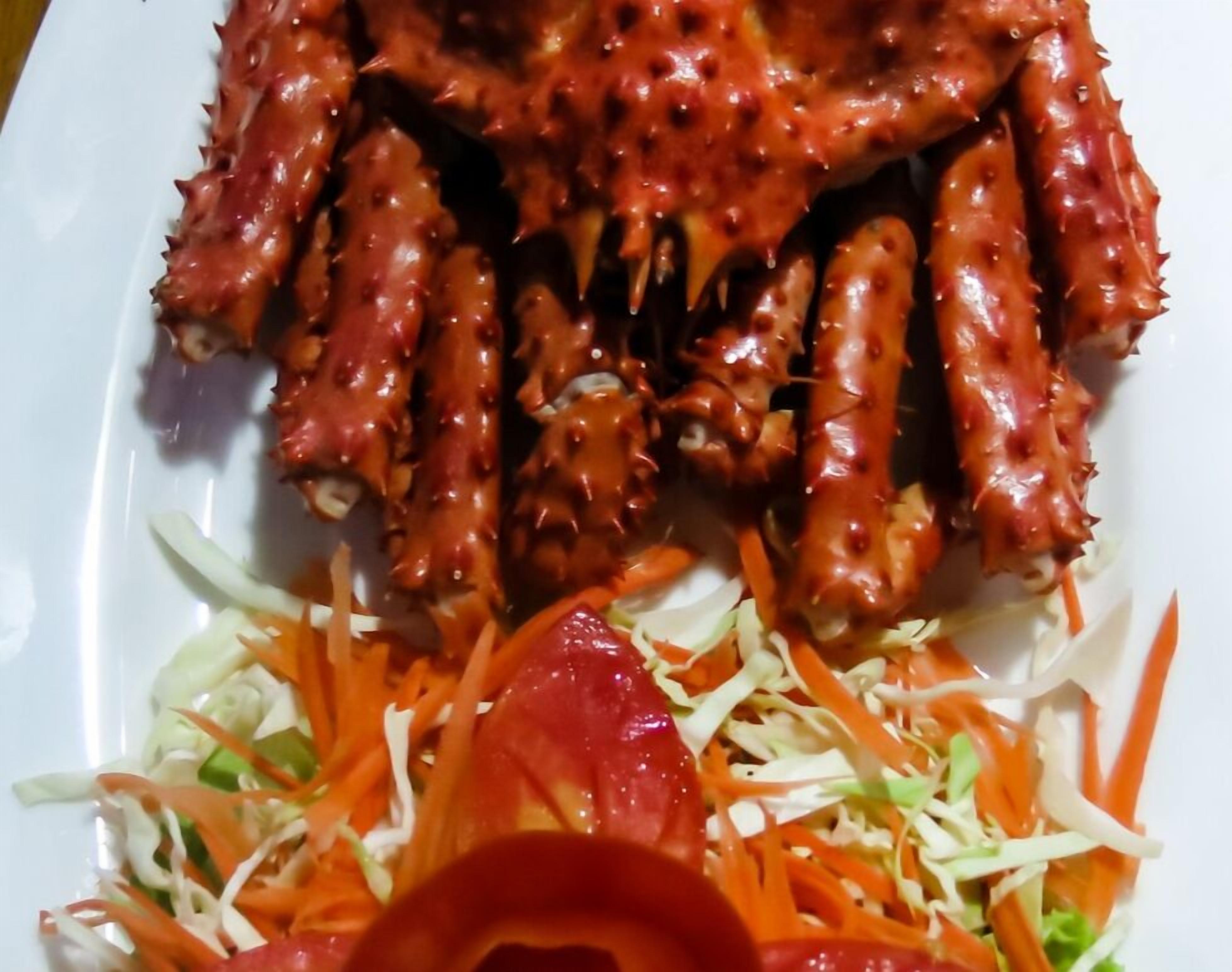 A plate of food with a spicy red sauce and a side salad.