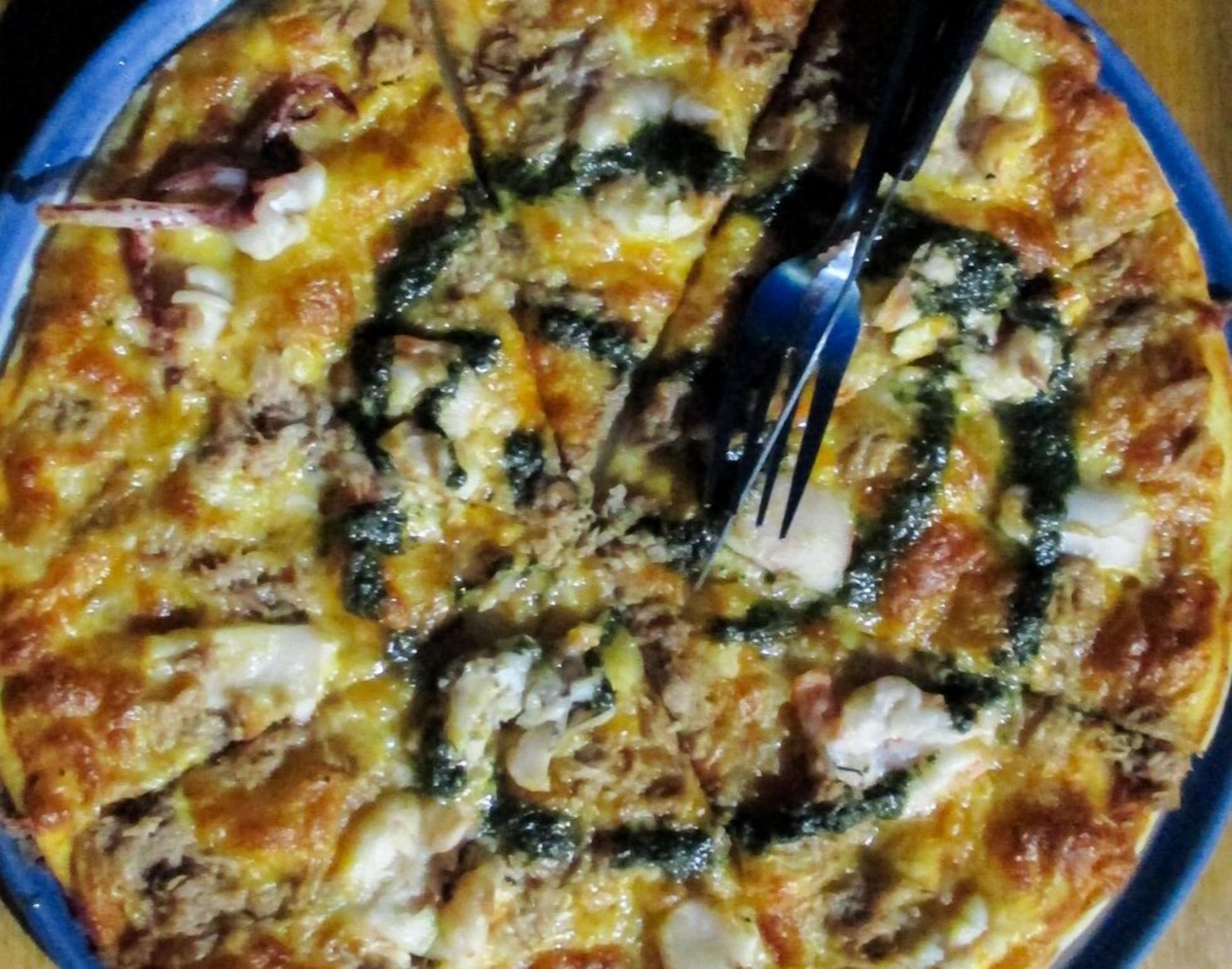 A pizza with visible toppings and a fork.