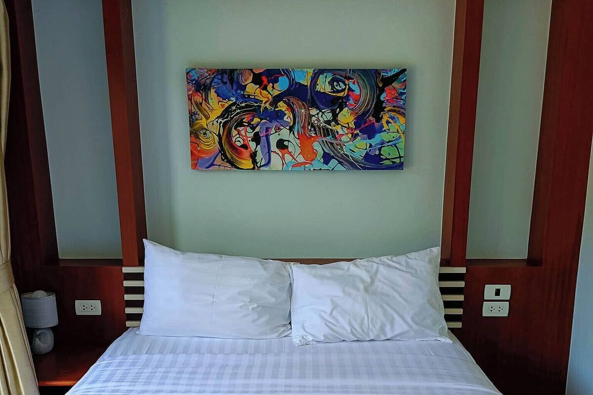 Una habitación de hotel con una cama grande, ropa de cama blanca y dos toallas dobladas sobre la cama.