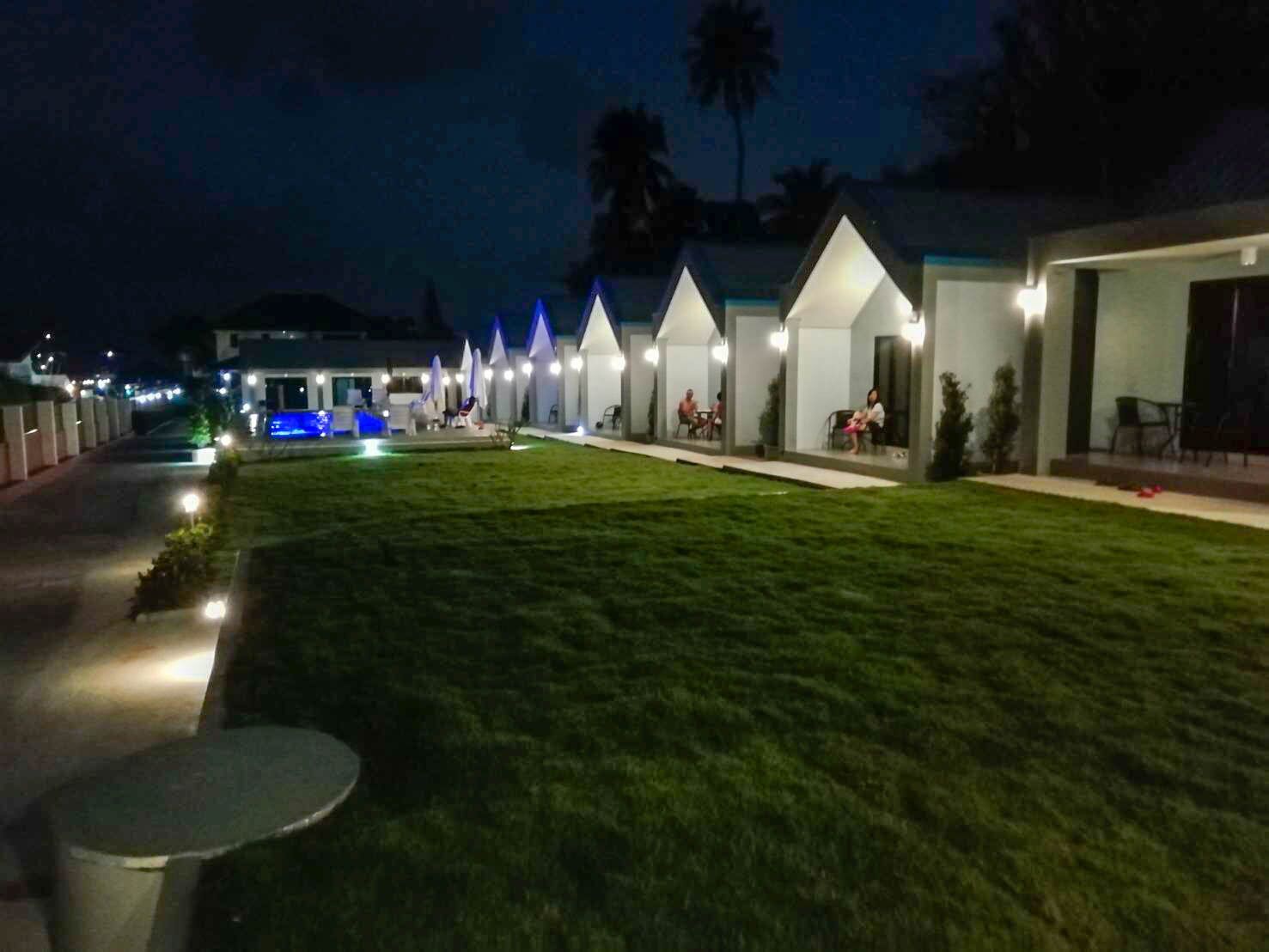 A row of white, triangular-roofed buildings with outdoor seating areas, connected by a pathway.