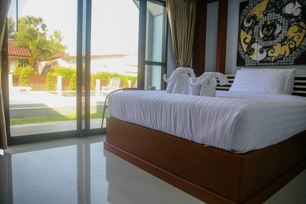 Un dormitorio con una cama grande, vistas al exterior y un cuadro en la pared.