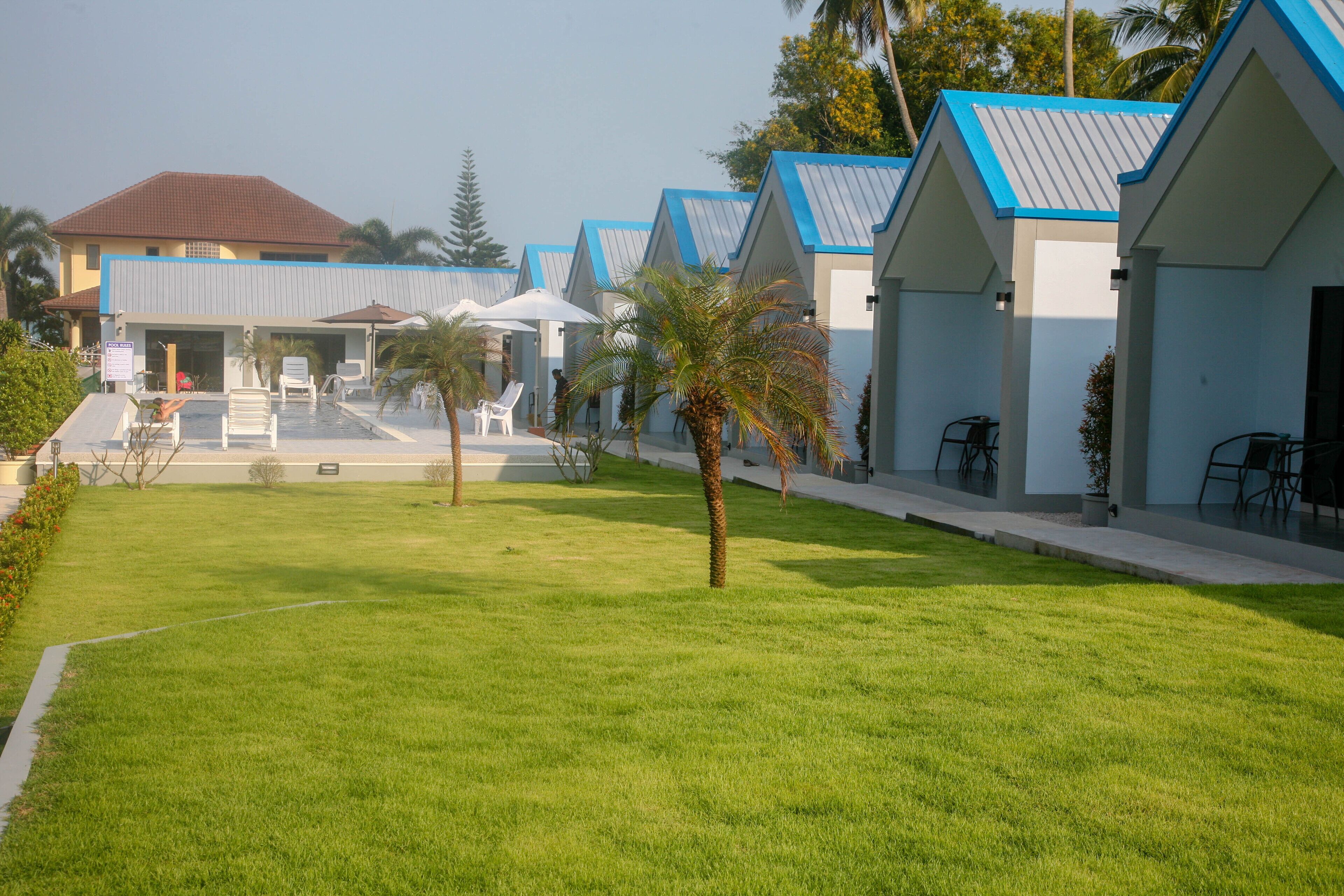 A row of modern, single-story buildings with blue roofs and white walls, likely part of a hotel or resort.