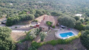 An aerial view of a property with a swimming pool, stone house, and surrounding greenery. - 3 bedroom villa with swimming pool in a natural setting  (Arzachena SARDAIGNE)