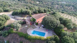 An aerial view of a property with a swimming pool, stone walls, and surrounding greenery. - 3 bedroom villa with swimming pool in a natural setting  (Arzachena SARDAIGNE)