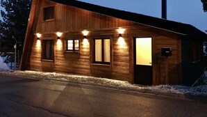 A wooden cabin with a sloped roof, multiple windows, and a chimney. - Chalet Les Angles 1900m (Les Angles)