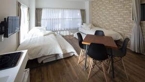 Une chambre d’hôtel avec un lit, un bureau et une chaise, une télévision et un mur en briques.
