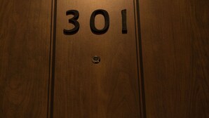 Une porte en bois portant le numéro « 301 » en relief.