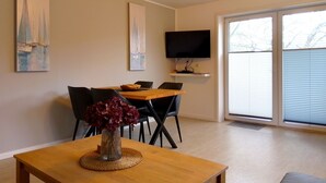 En matplats med ett bord, stolar, en vas med blommor och konstverk på väggarna.