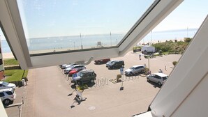 A parking area with vehicles and a view of the beach through a window. - Am Wasser OG, Germany (Hörnum (Sylt))