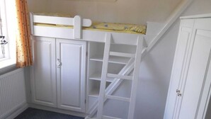 A room with a bunk bed, built-in wardrobe, and a ladder.