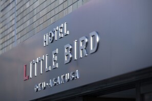 A hotel sign with the name "HOTEL LITTLE BIRD" and the location "KU-AISAKUYA".