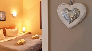 Una habitación de hotel con cama, almohadas y una mesita de noche con lámpara.