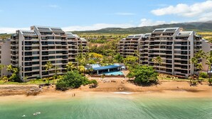 Un hotel moderno con varias plantas, piscina y vista al mar.