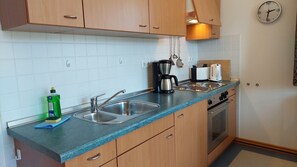 Een koelkast, een oven, een koffiezetapparaat/waterkoker, een waterkoker