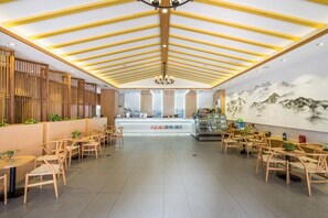 A spacious hotel lobby with wooden furniture, a reception desk, and a mural of mountains. - Vyluk J Hotel Zhongshan Road Wuxi (Wuxi)