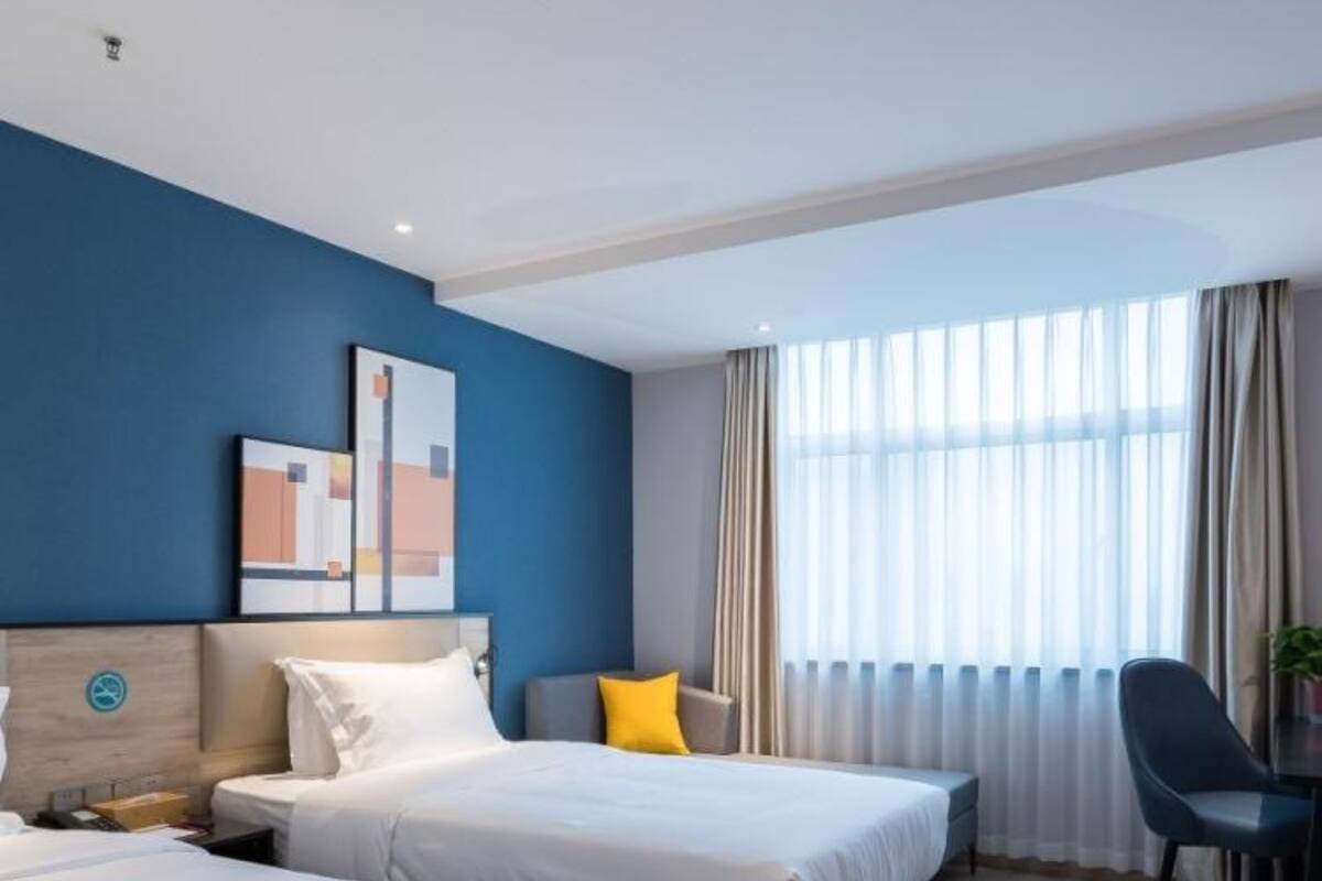 Ein Hotelzimmer mit zwei Betten, einem Schreibtisch und einem Stuhl.