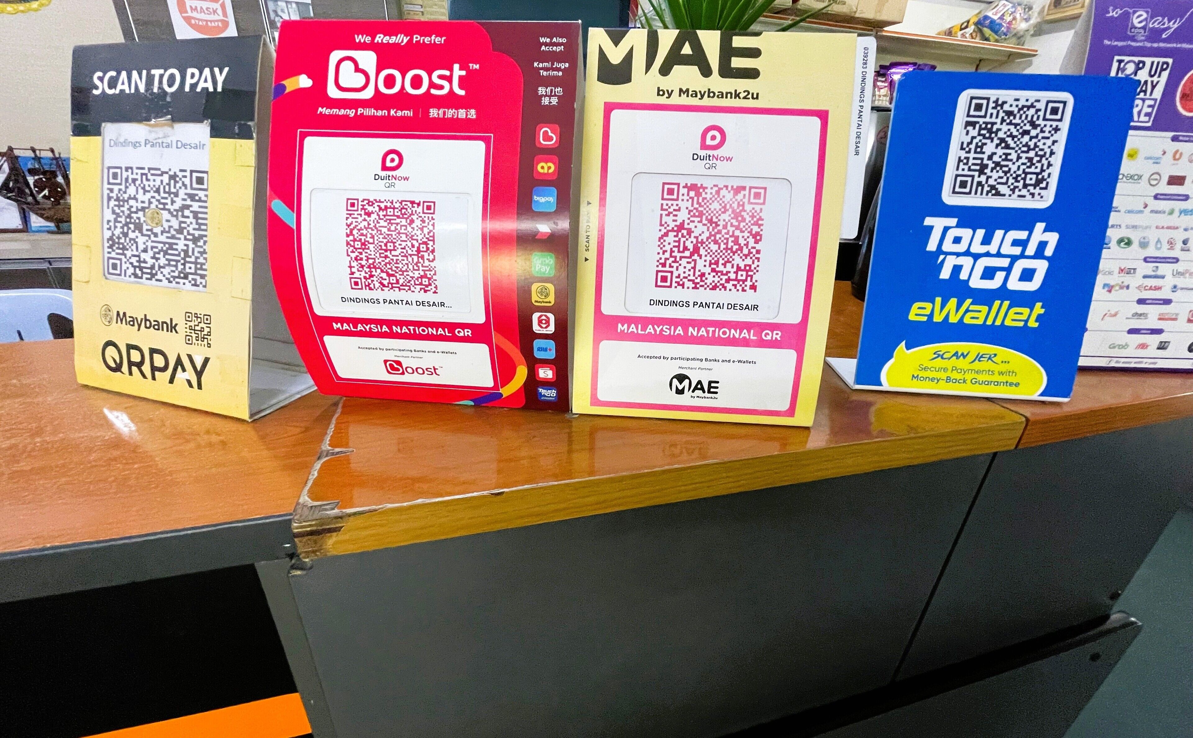En presentation av olika alternativ för betalning via QR-kod, inklusive Maybank QRPay, Boost och Touch 'N Go eWallet.