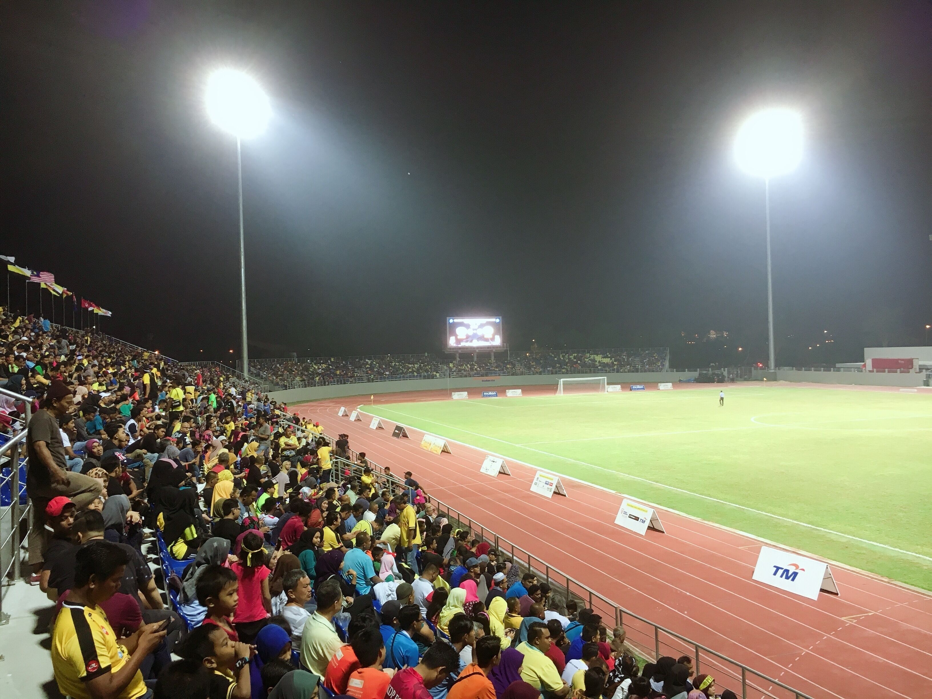 Un estadio con pista y una gran multitud de espectadores.