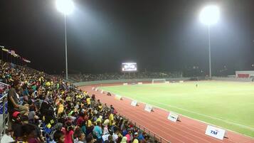 Un estadio con pista y una gran multitud de espectadores.