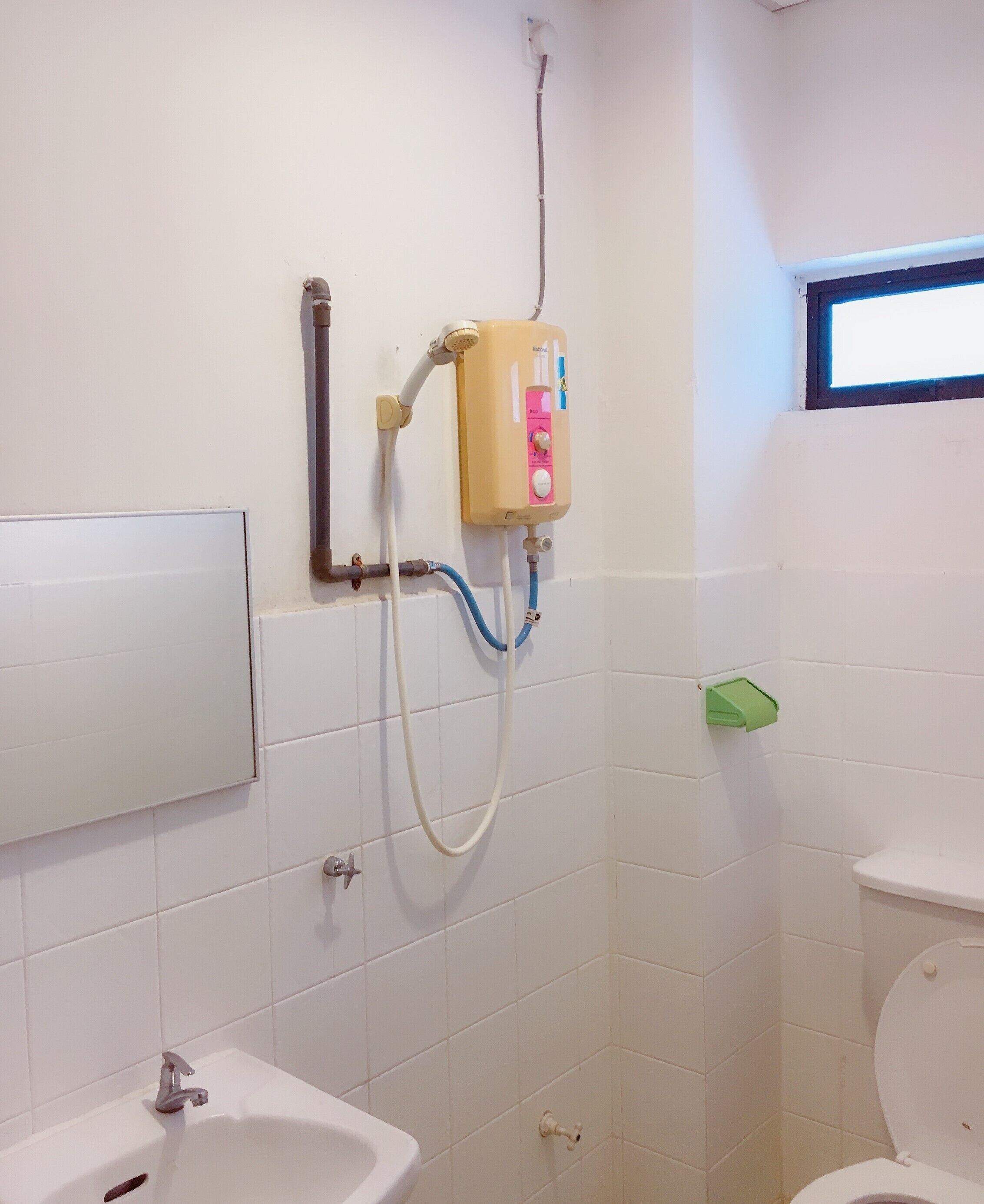 A bathroom with a shower, toilet, and sink.