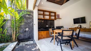 A modern kitchen with wooden cabinets, a black backsplash, and a dining area with a table and chairs.