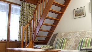 A wooden staircase leading to a loft bedroom with a bed, pillows, and a framed picture on the wall. - Apartment 1: Apartment in private property with quiet courtyard (Bergheim)
