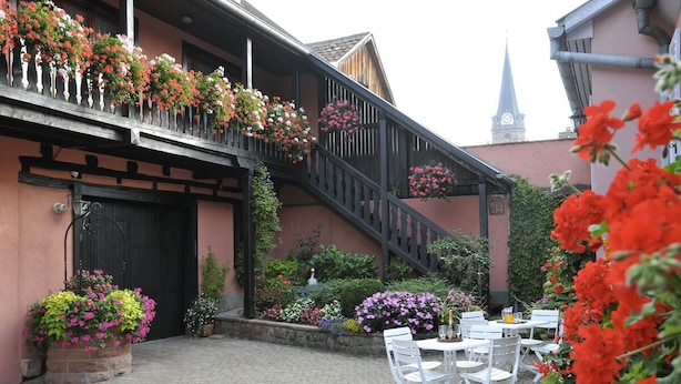 A traditional building with a staircase, outdoor seating area, and flower boxes. - Apartment 1: Apartment in private property with quiet courtyard (Bergheim)