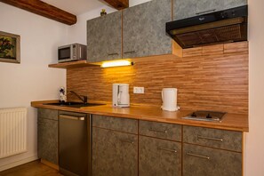 Eine Küche mit Holzarbeitsplatte, eingebauter Mikrowelle, Kaffeemaschine und Geschirrspüler.