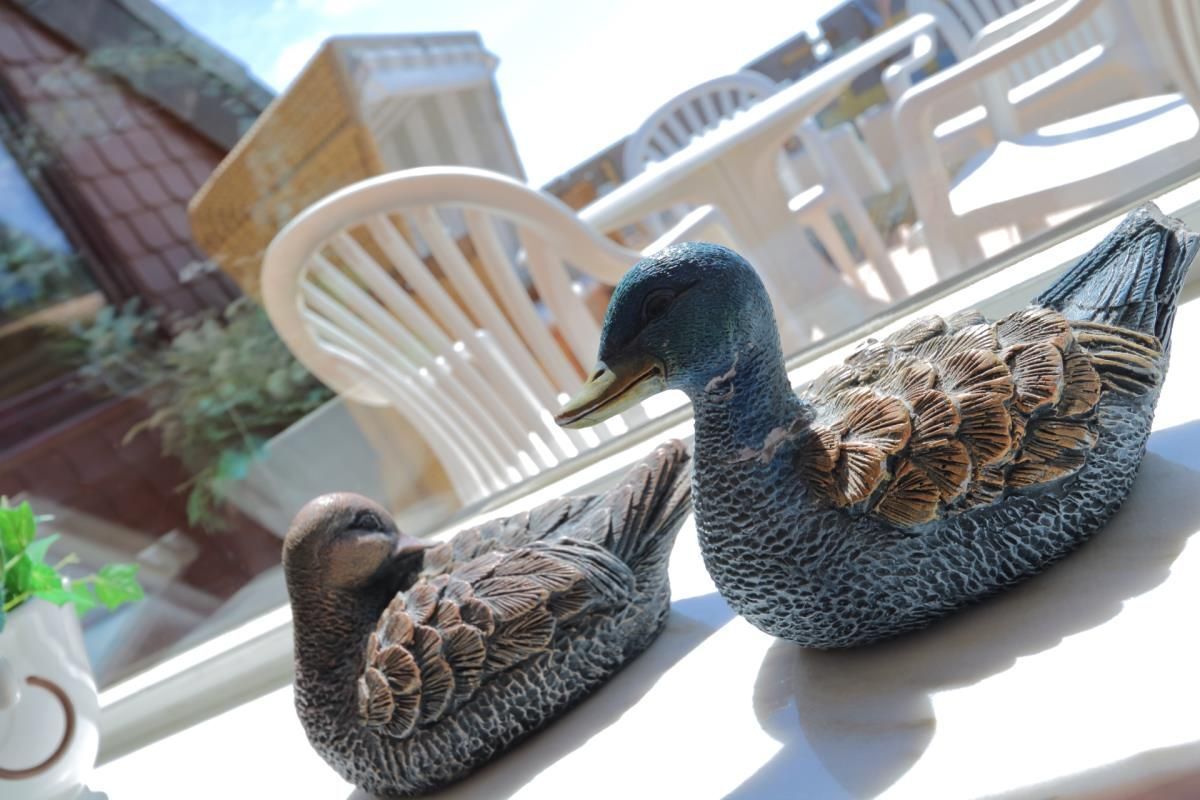 Two bird-shaped sculptures on a windowsill.