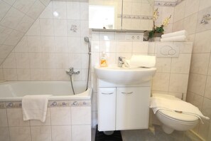 A bathroom with a bathtub, sink, and toilet, all in white.