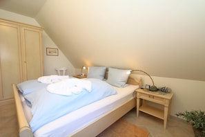 Ein Schlafzimmer mit Bett, Nachttisch, Lampe und Kleiderschrank.