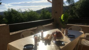 A table set outdoors with a view of trees and hills. - Beautiful Villa in Green Provence with Swimming Pool and Bowling Alley (Tourves)