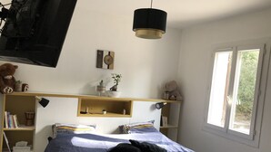 A bedroom with a bed, a desk, shelves, a window, and a hanging lamp. - Beautiful Villa in Green Provence with Swimming Pool and Bowling Alley (Tourves)