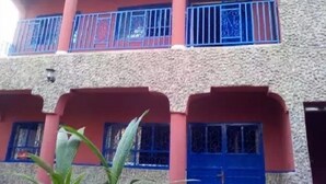 A multi-story building with balconies and blue-framed windows. - Hakaba (Conakry)