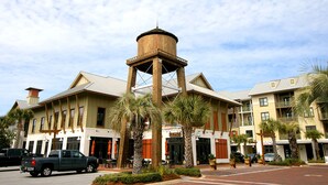 Ein Hotel mit einem zentralen Wasserturm, mehreren Stockwerken und Palmen.