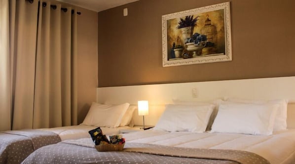 A hotel room with two beds, a painting on the wall, a nightstand with a lamp, and a basket of toiletries on the bed. - Thermas Classic Hotel (Marcelino Ramos)
