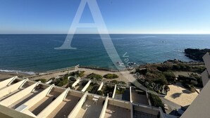 A rooftop terrace with a view of the ocean and rocky coastline.