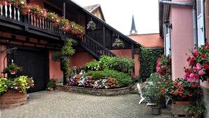 A courtyard with a wooden staircase, potted plants, and a brick pathway. - Detached house in a quiet private courtyard in the heart of Bergheim (Bergheim)
