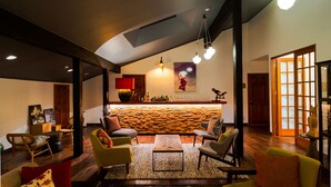 A spacious living area with a modern kitchen in the background, wooden flooring, and a variety of seating options. - Numajiri kogen lodge (Inawashiro)